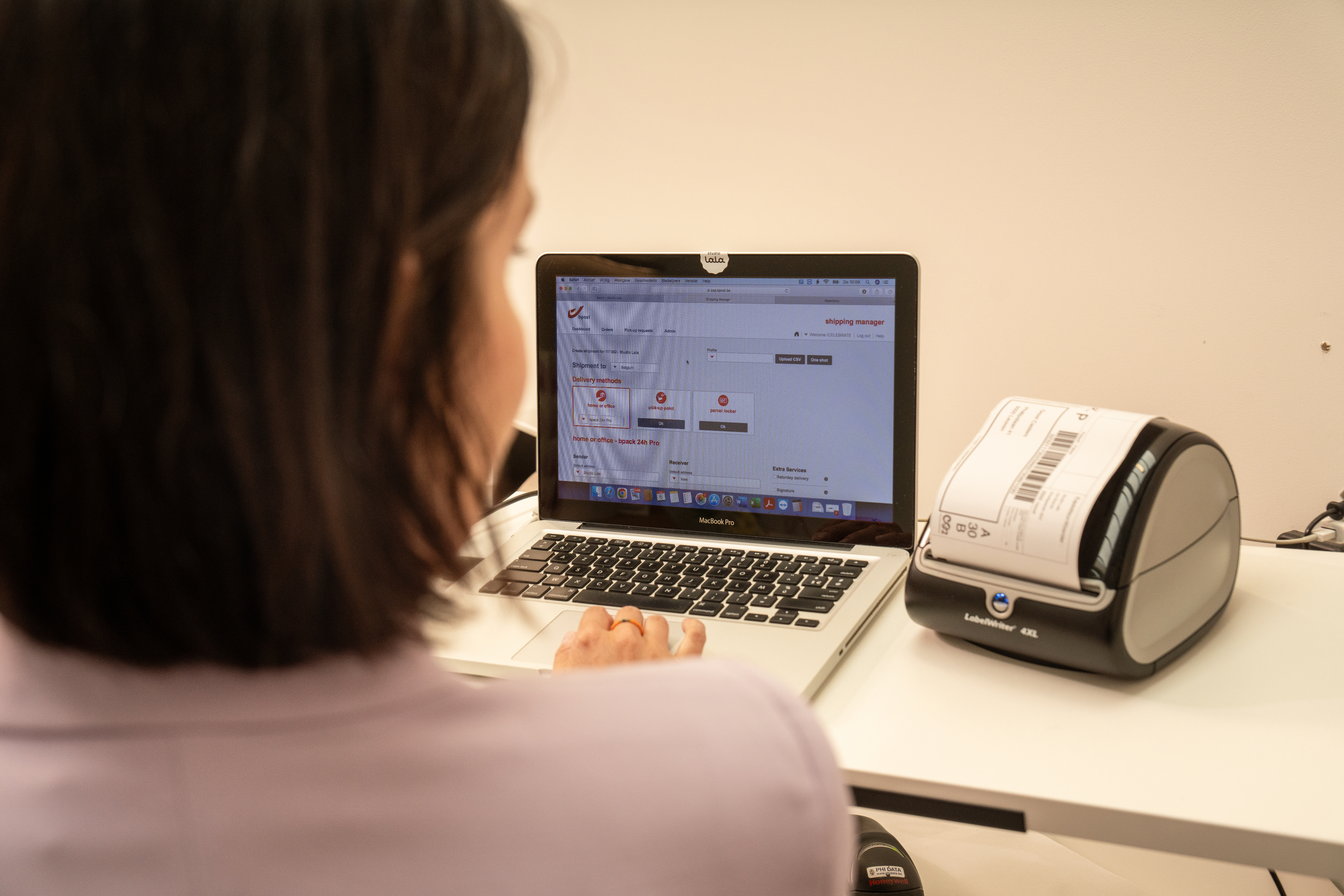 Woman with a laptop and a label printer